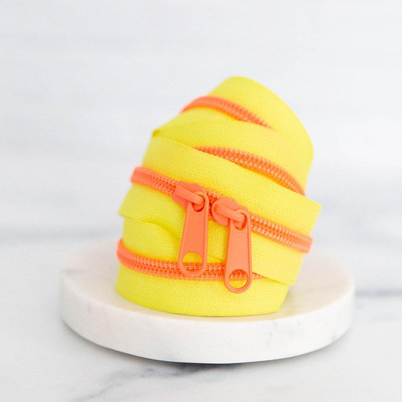 30" zipper Highlighter. Bright yellow and hot coral zipper on a white background