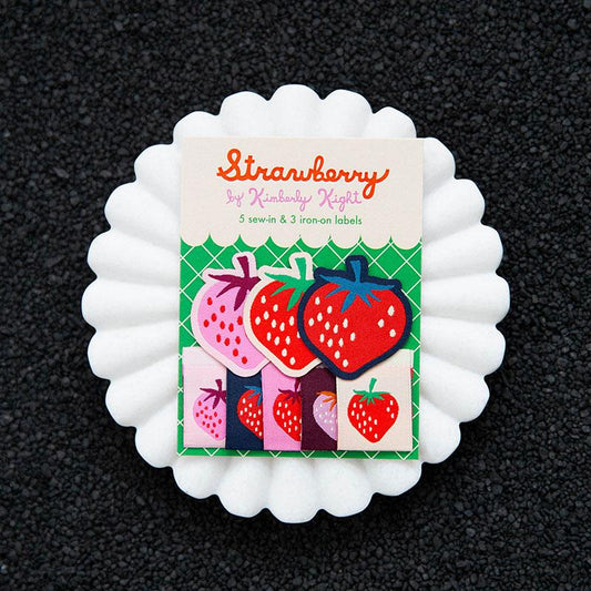 Pack of strawberry-themed sewing labels on a black background