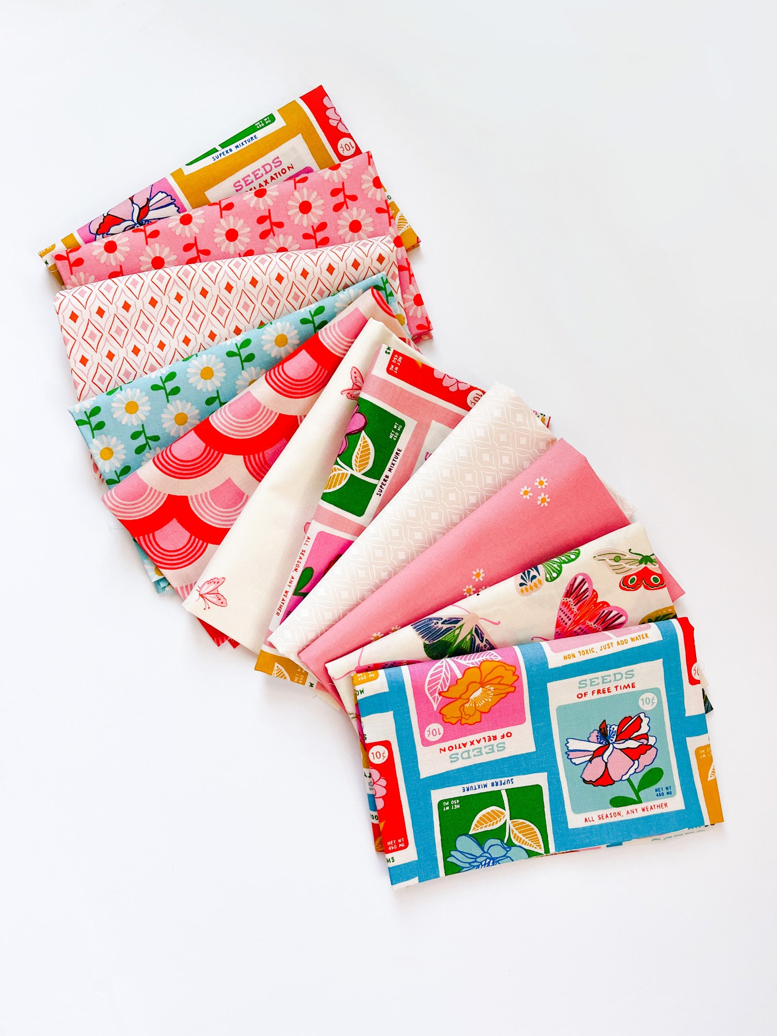 Flowerland fat quarters, florals and butterflies and seed packets in vibrant pinks, blues and greens. 