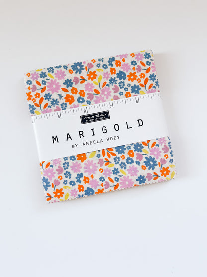 Aneela Hoey Marigold Charm Pack on white background with a floral print fabric showing
